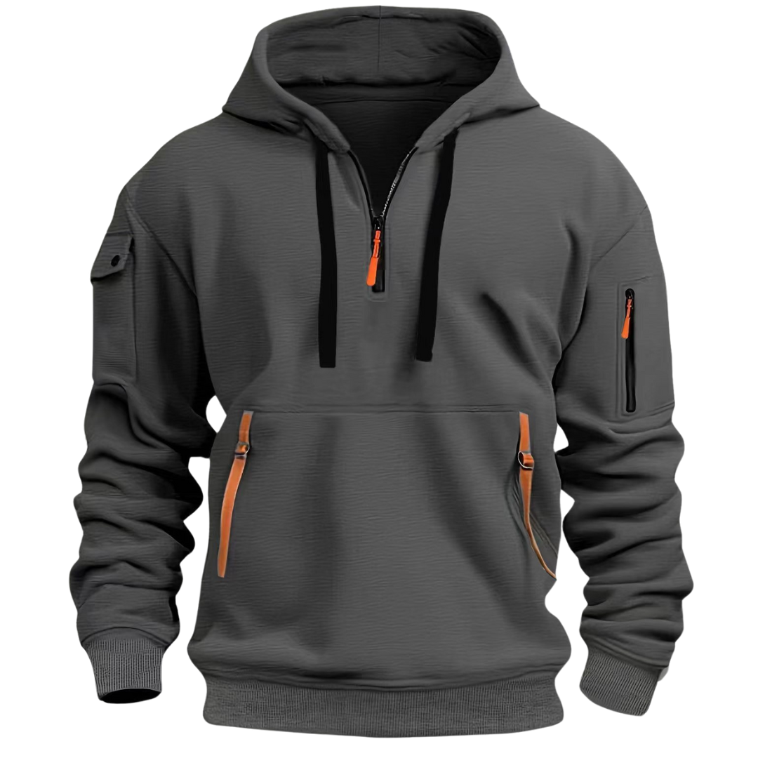 Sudadera gris de manga larga con capucha, detalles en naranja y múltiples bolsillos con cremallera. El diseño es moderno y adecuado para uso casual o deportivo.